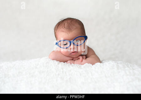 Portrait von 9 Tag alt, neugeborene Mädchen. Sie ist blau tragen, Katze Brille und schaut in die Kamera. Stockfoto