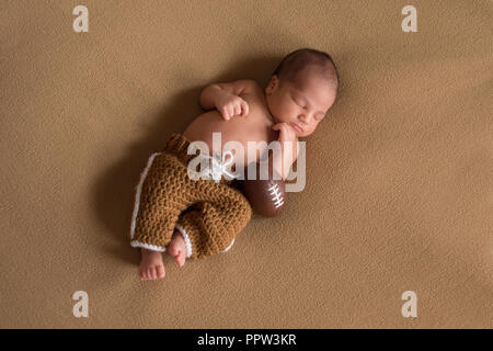 Ein Schlafzimmer, 9 Tag alt neugeborenes Baby Boy tragen Gestricken Fußball einheitliche Hosen. Stockfoto