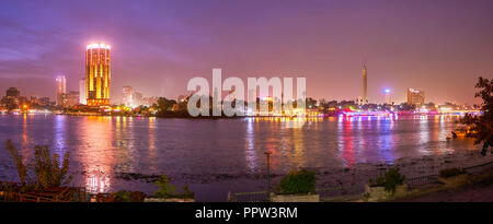 Die schöne Aussicht auf die beleuchteten Hochhäuser auf der Bank von Gizeh Stadt von der Corniche El-Nil Promenade von Kairo, Ägypten Stockfoto