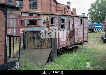 Narrow-gauge railway station in einer kleinen Stadt. Wagen und Lokomotiven auf einem Abstellgleis in der Werkstatt. Jahreszeit der Herbst. Stockfoto