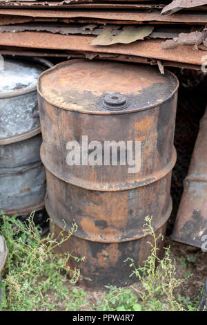 Alte Fässer für Diesel. Metallbehälter für Öl auf dem Schrottplatz. Jahreszeit der Herbst. Stockfoto