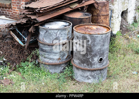 Alte Fässer für Diesel. Metallbehälter für Öl auf dem Schrottplatz. Jahreszeit der Herbst. Stockfoto