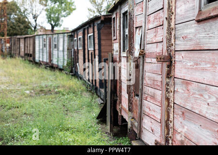 Narrow-gauge railway station in einer kleinen Stadt. Wagen und Lokomotiven auf einem Abstellgleis in der Werkstatt. Jahreszeit der Herbst. Stockfoto