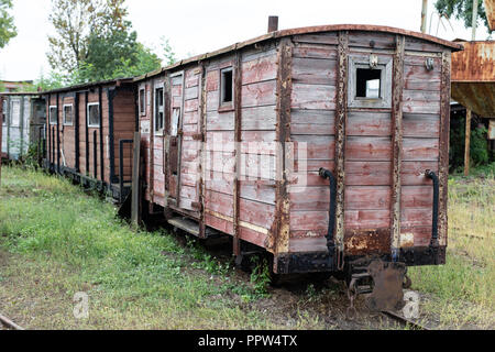 Narrow-gauge railway station in einer kleinen Stadt. Wagen und Lokomotiven auf einem Abstellgleis in der Werkstatt. Jahreszeit der Herbst. Stockfoto