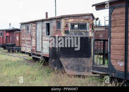 Narrow-gauge railway station in einer kleinen Stadt. Wagen und Lokomotiven auf einem Abstellgleis in der Werkstatt. Jahreszeit der Herbst. Stockfoto