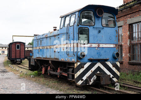 Narrow-gauge railway station in einer kleinen Stadt. Wagen und Lokomotiven auf einem Abstellgleis in der Werkstatt. Jahreszeit der Herbst. Stockfoto