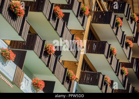 An einem sonnigen Tag im September die Sonne scheint auf mehrere Balkone, dekoriert mit roten Blumen in Newbury. Stockfoto