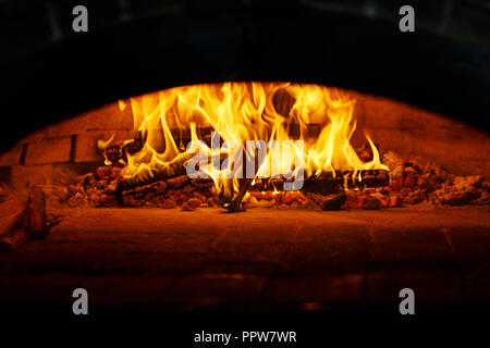 Flammen im Ofen. Schöne Feuer brennt im Ofen. Kochen Pizza im Cafe. Stockfoto