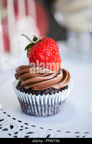 Schokoladenkuchen mit Erdbeeren im Cafe auf dem Tisch. Stockfoto