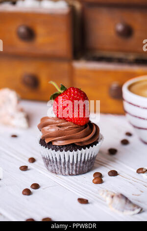 Schokolade Kuchen mit Erdbeeren und ein Kaffee trinken auf den Tisch. Stockfoto