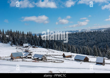 Alpine Village in Siebenbürgen, Rumänien. Schnee bedeckte Häuser im Winter Stockfoto