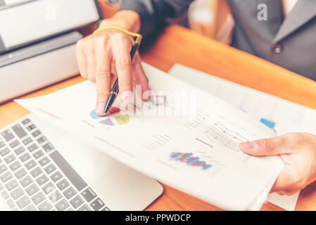 Attraktive Junge Büro Geschäftsmanns, der auf den Geschäftspapieren und lehnte sich an ihn. Stockfoto