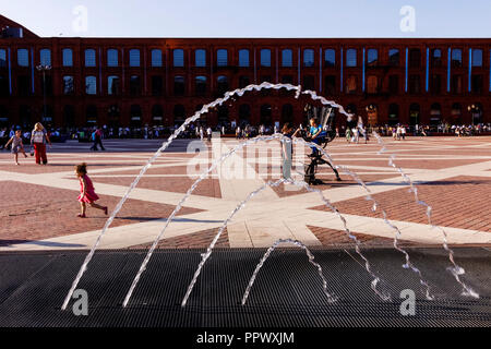 Lodz, Polen: Kinder spielen mit einem dekorativen Springbrunnen am Hauptplatz in Manufaktura Arts Center, Shopping Mall, und Freizeitkomplex auf geöffnet Stockfoto