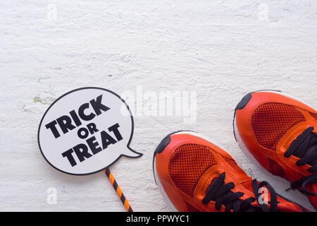 Happy Halloween Festival mit Sport Schuhe und Trick oder Festlichkeit Zeichen auf weißem Holz Hintergrund Stockfoto
