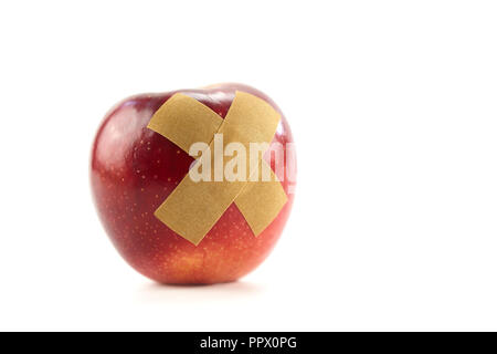 Red Apple mit Bandage auf weißem Hintergrund. Stockfoto