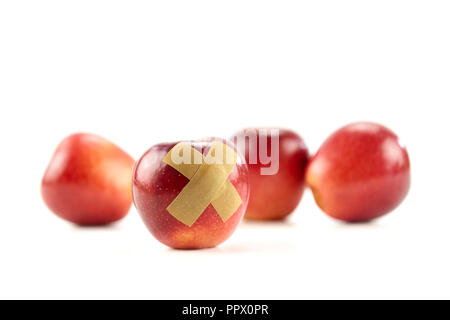 Red Apple mit Bandage auf weißem Hintergrund. Stockfoto