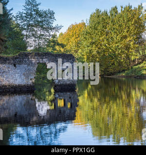 Malerischer Blick auf Thruscross Behälter mit zerbröckelnden Mauer von Flachs Mill Ruinen im Wasser spiegelt - Washburn Tal, North Yorkshire, England, UK. Stockfoto