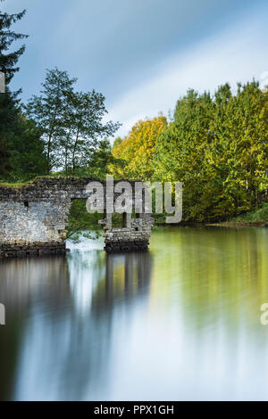 Malerischer Blick auf Thruscross Behälter mit zerbröckelnden Mauer von Flachs Mill Ruinen im Wasser spiegelt - Washburn Tal, North Yorkshire, England, UK. Stockfoto