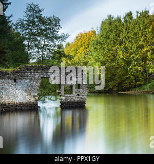 Malerischer Blick auf Thruscross Behälter mit zerbröckelnden Mauer von Flachs Mill Ruinen im Wasser spiegelt - Washburn Tal, North Yorkshire, England, UK. Stockfoto