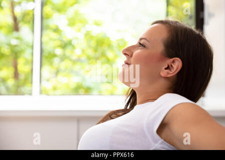 Nahaufnahme einer Lächelnden jungen Frau zu Hause Stockfoto