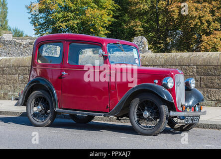 Red austin Austin Seven (7) Vintage Limousine ab 1938 am Straßenrand in Großbritannien geparkt. Stockfoto