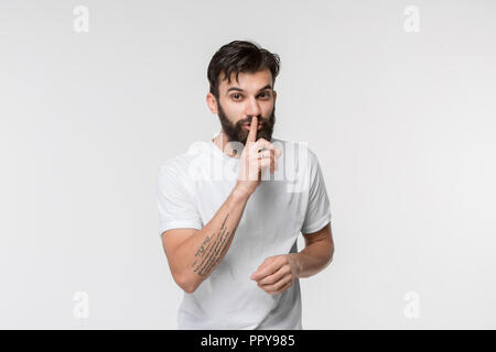 Geheimnis, Klatsch-Konzept. Junger Mann flüsternd ein Geheimnis hinter seiner Hand. Geschäftsmann auf weiße studio Hintergrund isoliert. Junge Mensch. Menschliche Gefühle, Mimik Konzept. Stockfoto