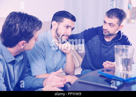 Zwei gestörte Männer, ernstes Gespräch mit ihrem Freund zu Hause Stockfoto
