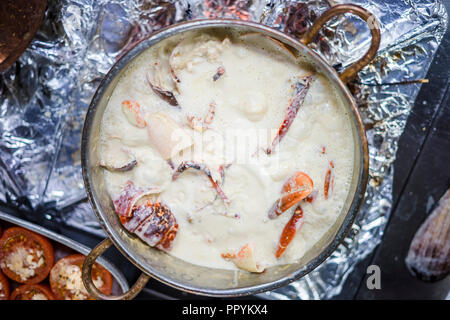 Hummersuppe auf Basis von Milch und Rotwein in Kupfer Topf zubereitet Stockfoto