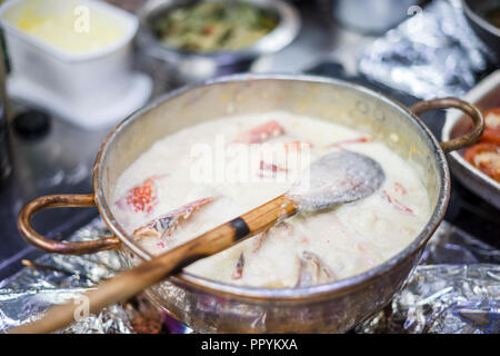 Hummersuppe auf Basis von Milch und Rotwein in Kupfer Topf zubereitet Stockfoto