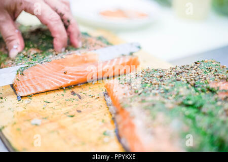 Schneiden lecker Lachs mit Kräutern in Scheiben geschnitten als Vorspeise zu dienen Stockfoto