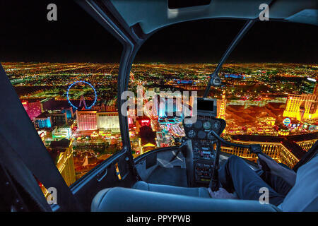 Hubschrauber Innenraum auf Las Vegas Gebäuden und Wolkenkratzern in Downtown mit beleuchteten Casino Hotels in der Nacht. Rundflug über Vegas Skyline bei Nacht in die Nevada Vereinigte Staaten von Amerika. Stockfoto