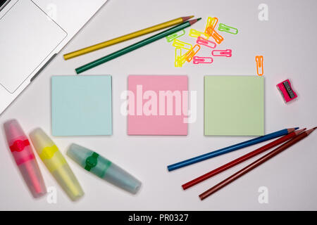 Haftnotizen mit Marker, farbige Stifte, Büroklammern Festlegung auf einen Tisch, zurück in die Schule. Schul- und Büromaterial. Stockfoto