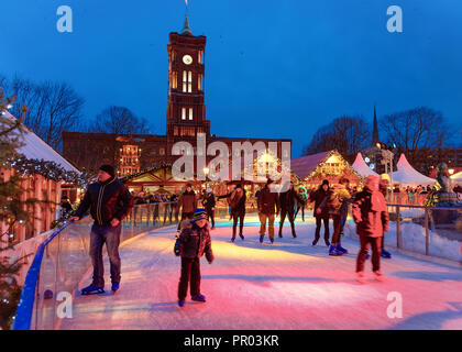 Berlin, Deutschland - 10. Dezember 2017: Menschen auf der Eisbahn in der Nacht Weihnachtsmarkt am Rathaus im Winter Berlin, Deutschland. Christkindlmarkt Dekoration Stockfoto