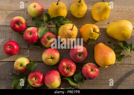 Flach auf Äpfel und Birnen Hintergrund, auf alten Holztisch. Stockfoto