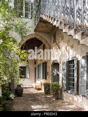 Äußere Steintreppe mit Fensterläden aus duftendem Zedernholz und ursprünglichen Eisengeländern. Stockfoto