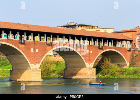 Ein Boot navigiert unter dem Ponte Coperto, Pavia, Provinz Pavia, Lombardei, Italien, Europa Stockfoto