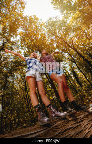 Schöne junge Mädchen Spaß im Wald. Es gibt wenige umgefallen Baum mit ausgestreckten Armen. Stockfoto