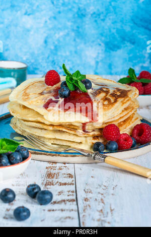 Einen Stapel Pfannkuchen mit frischem Obst, Marmelade und Sahne auf einer Platte Stockfoto