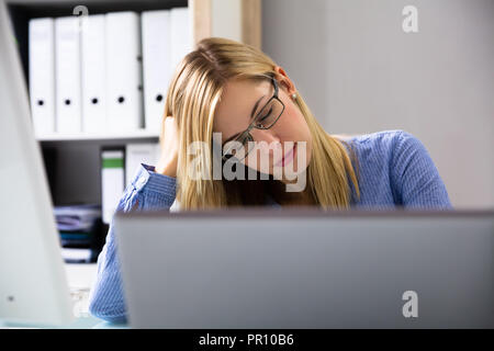 Foto von schönen jungen Geschäftsfrau schlafen im Büro Stockfoto