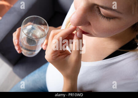 Nahaufnahme einer schwangeren Frau Hand Einnahme von Medizin Stockfoto
