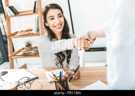 Portrait von fröhlichen asiatischen Geschäftsfrau Händeschütteln mit Kollegen Stockfoto