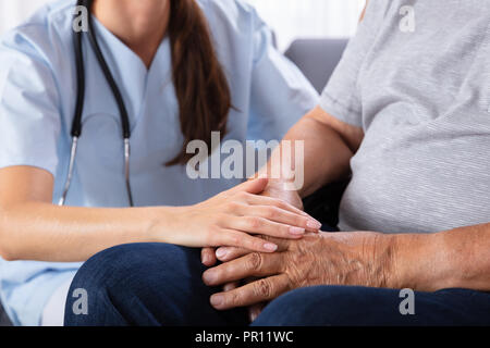 Porträt eines lächelnden älteren Mann sitzt im Rollstuhl mit weiblichen Krankenschwester Stockfoto