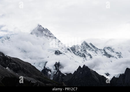 Masherbrum (K1) und Mandu Peak erscheint hinter Wolken, Baltoro Galcier, Goro II Campingplatz, Karakorum, Pakistan Stockfoto