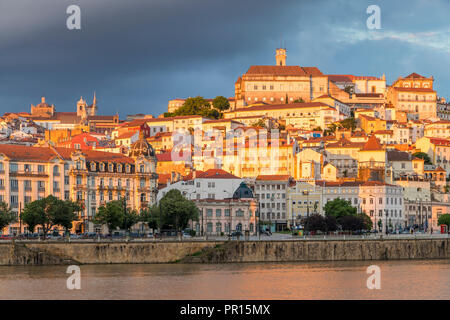 Blick von Mondego Fluss auf die Altstadt mit der Universität auf dem Hügel bei Sonnenuntergang, Coimbra, Portugal, Europa Stockfoto