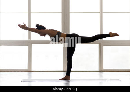 Junge sportliche Frau Üben Yoga, Krieger 3 Stockfoto