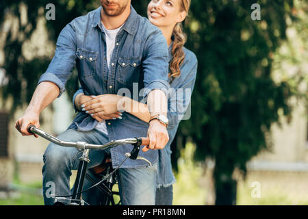 7/8 Schuß des jungen Paares Fahrrad zusammen reiten im Park Stockfoto