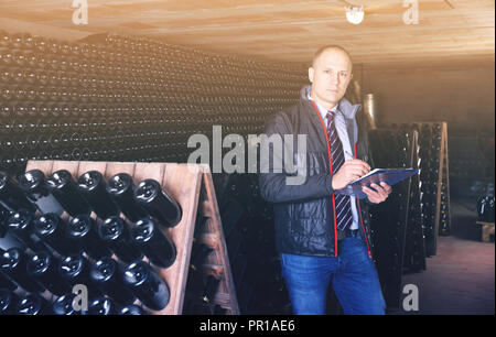 Winzer controlling Produktion Wein im Weingut Vault, fest im Notebook Stockfoto