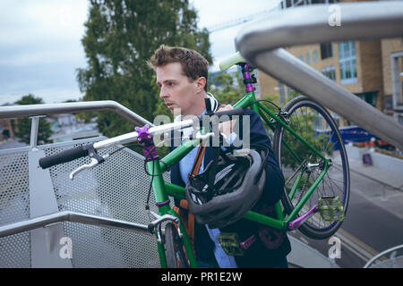 Geschäftsmann zu Fuß die Treppen mit Fahrrad Stockfoto