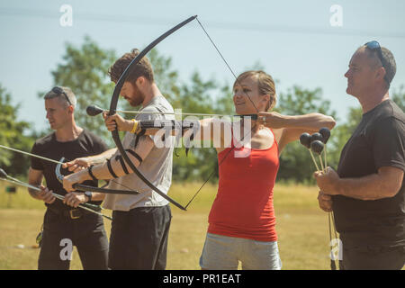 Trainer unterweisen Frau über Bogenschießen Stockfoto