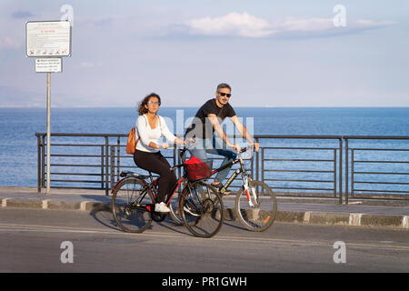 Santa Teresa di Riva, Italien, 24. September 2017: Paar auf Fahrrädern in der Straße in Santa Teresa di Riva in der Nähe von Messina, Sizilien, Italien Stockfoto